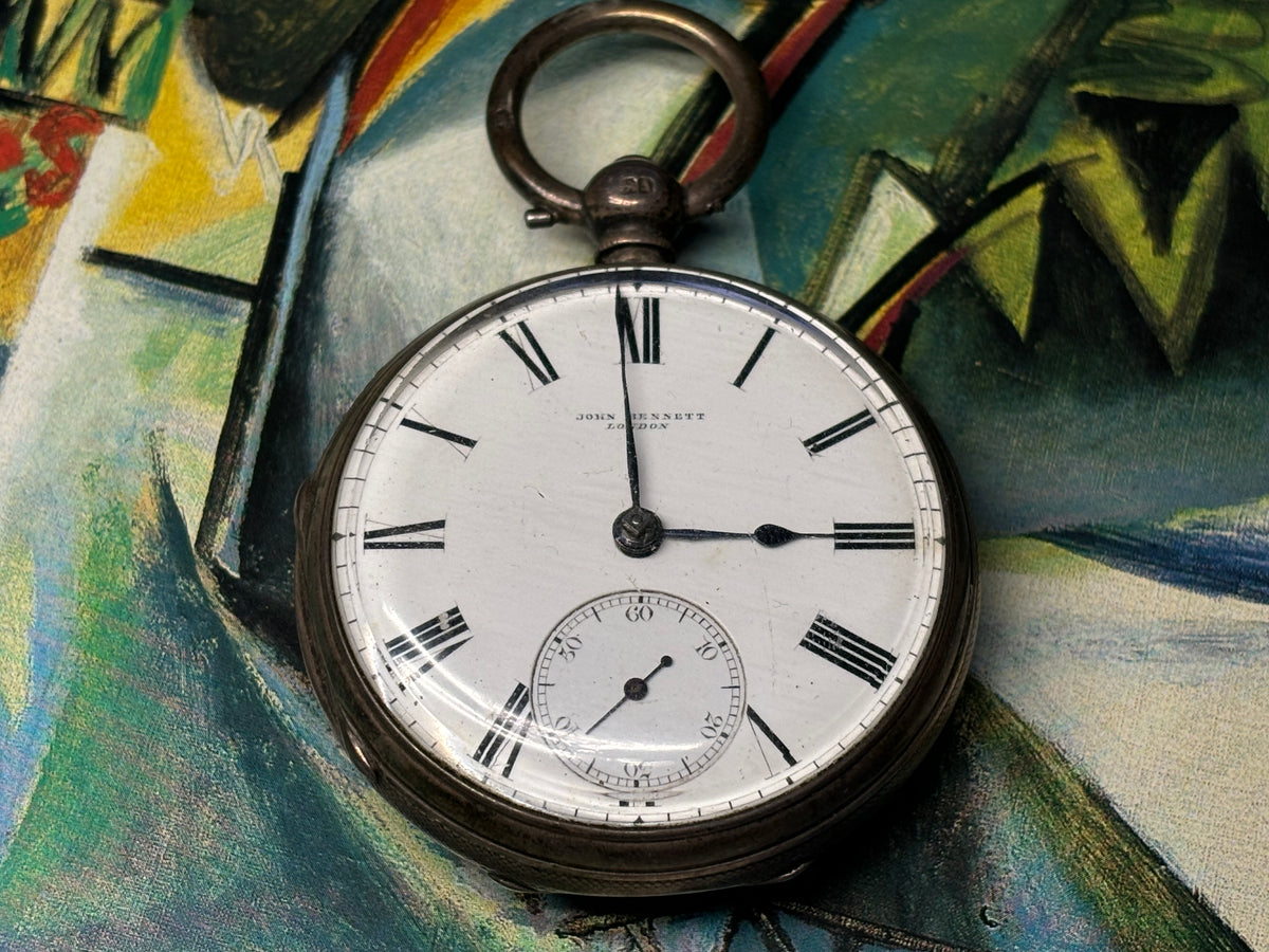 Front view of an antique John Bennett London pocket watch with Roman numeral dial and small seconds subdial.