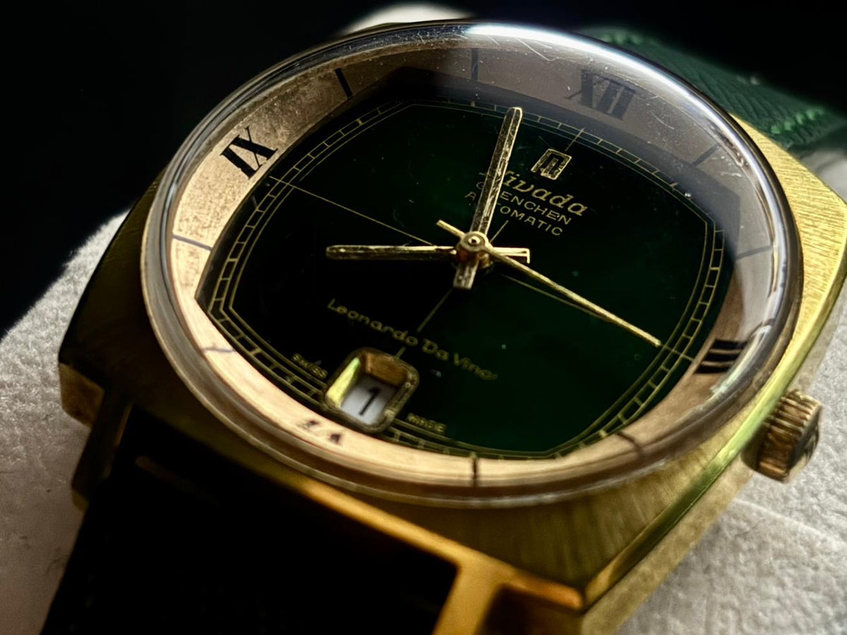 Detailed close-up of Nivada Grenchen Leonardo da Vinci automatic green dial, date display at 6 o’clock and gold-tone case