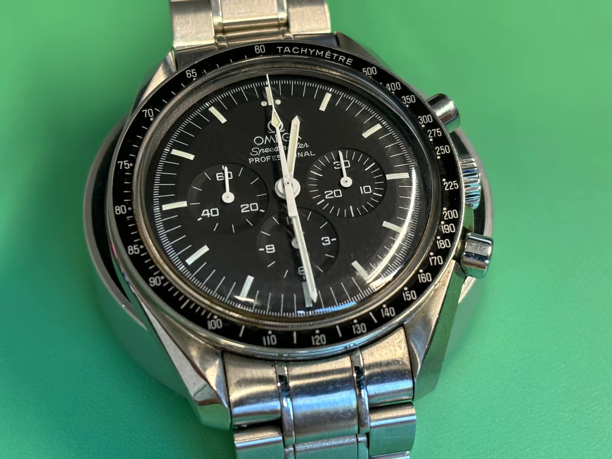Black chronograph dial and tachymeter bezel of an Omega Speedmaster Professional Moonwatch.