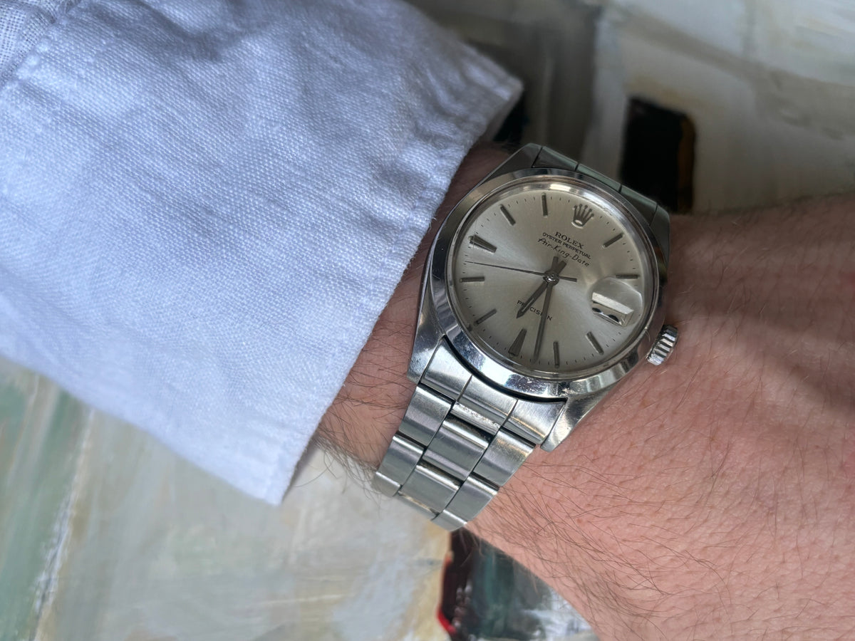 Vintage Rolex Air-King-Date Precision ref. 5700 worn on wrist with white shirt cuff and stainless-steel Oyster bracelet