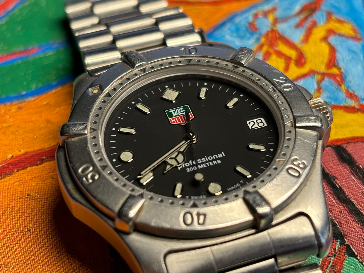 Front view of a vintage TAG Heuer Professional 200 Metres watch with black dial and date display.