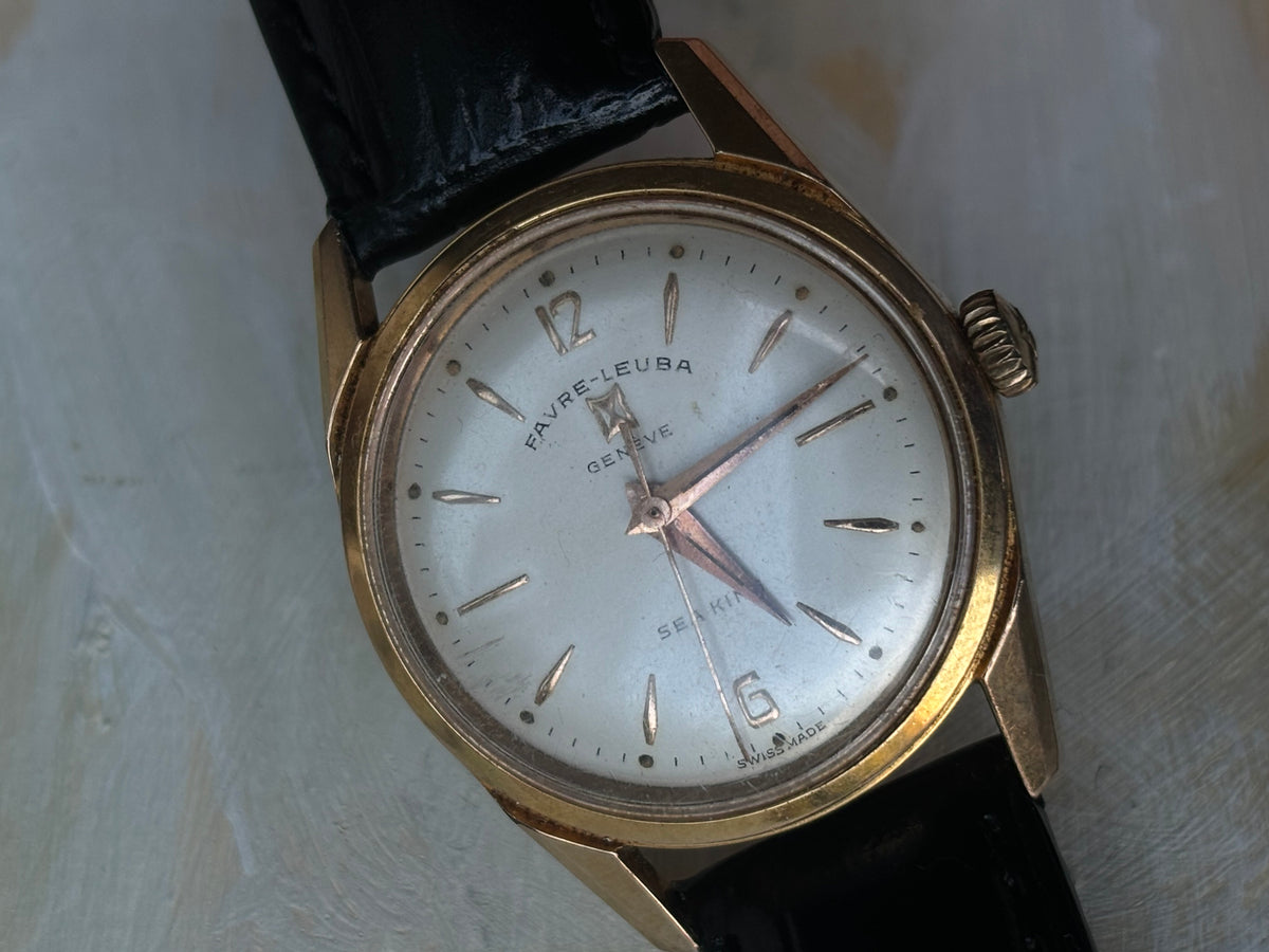 Close-up of the aged silver dial and applied markers on a Favre-Leuba Genève Sea King watch.