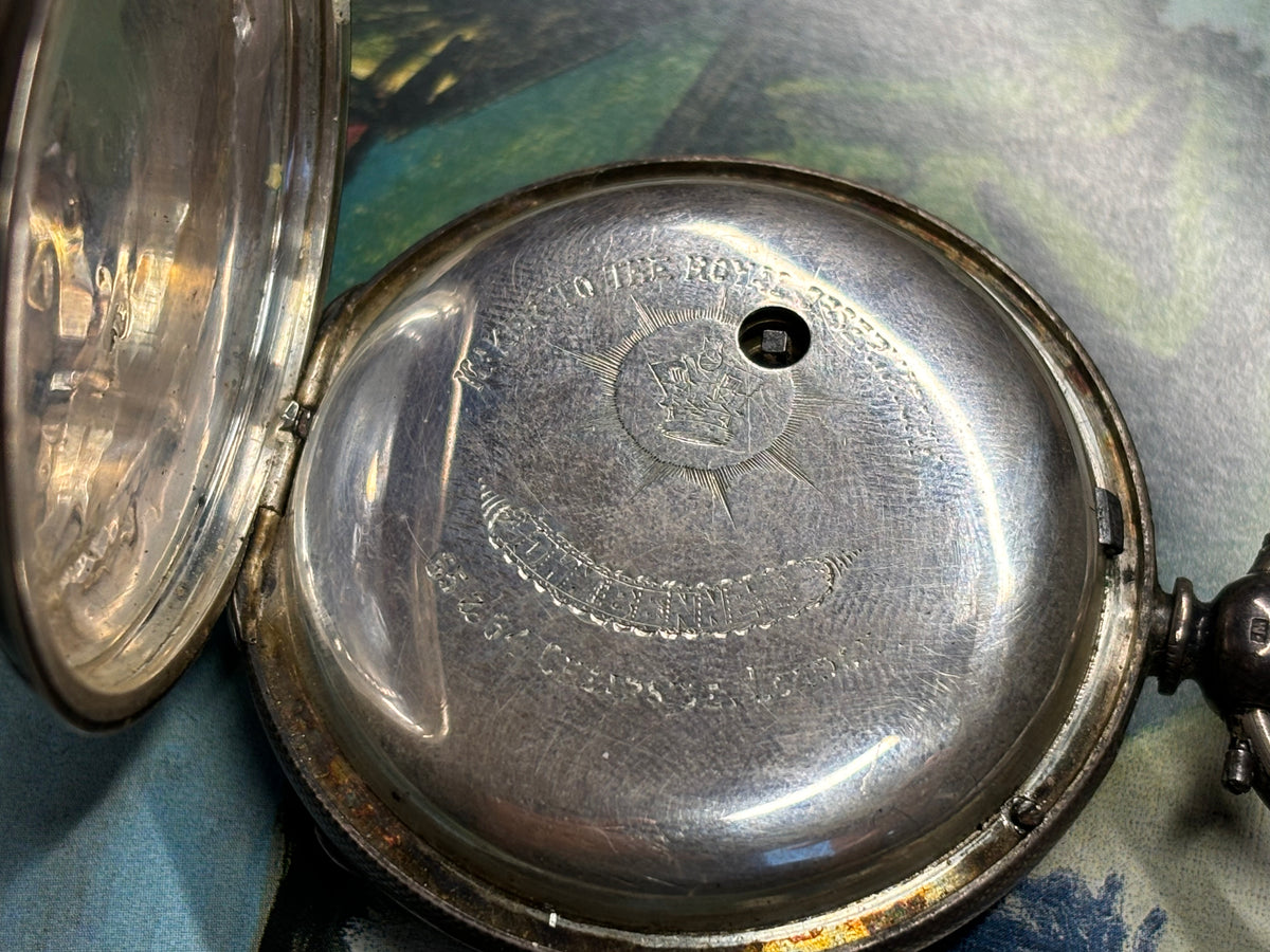 Close-up of the engraved inner case of an antique John Bennett London pocket watch.