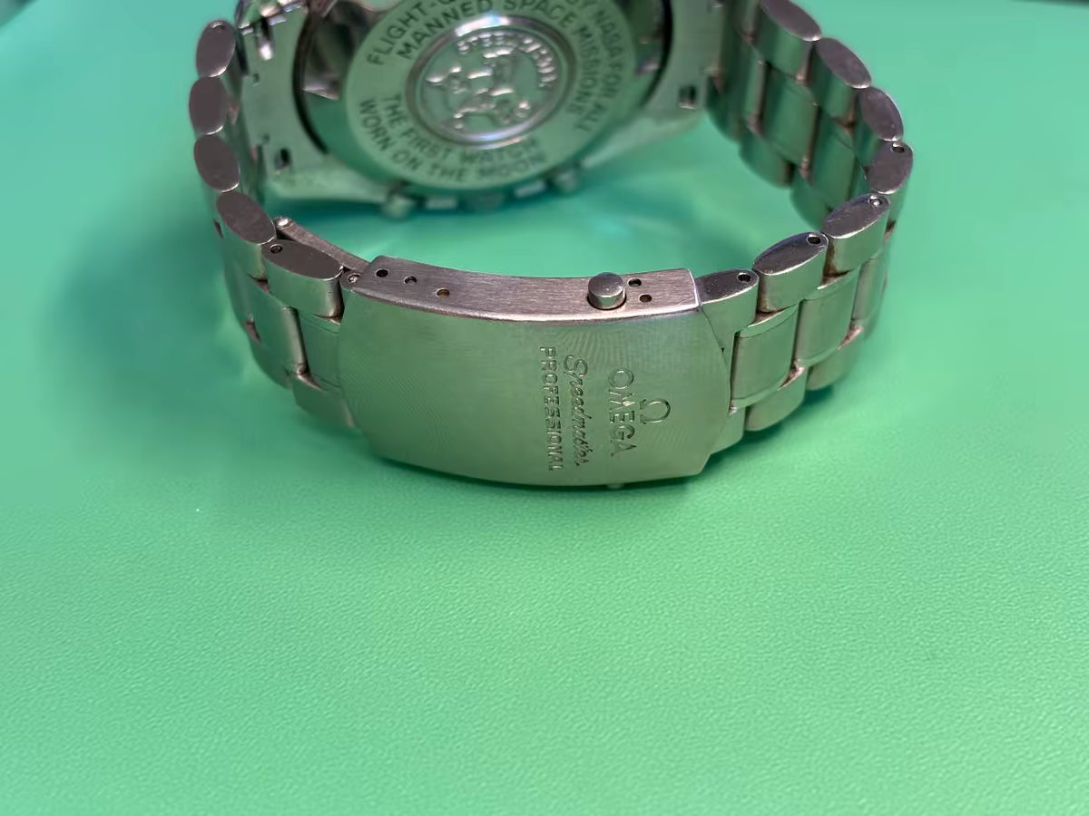 Open folding clasp on the stainless-steel bracelet of an Omega Speedmaster Professional Moonwatch.