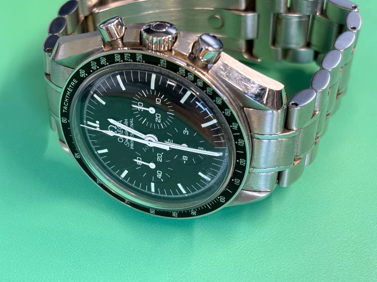Three-quarter view of an Omega Speedmaster Professional Moonwatch chronograph with tachymeter bezel.