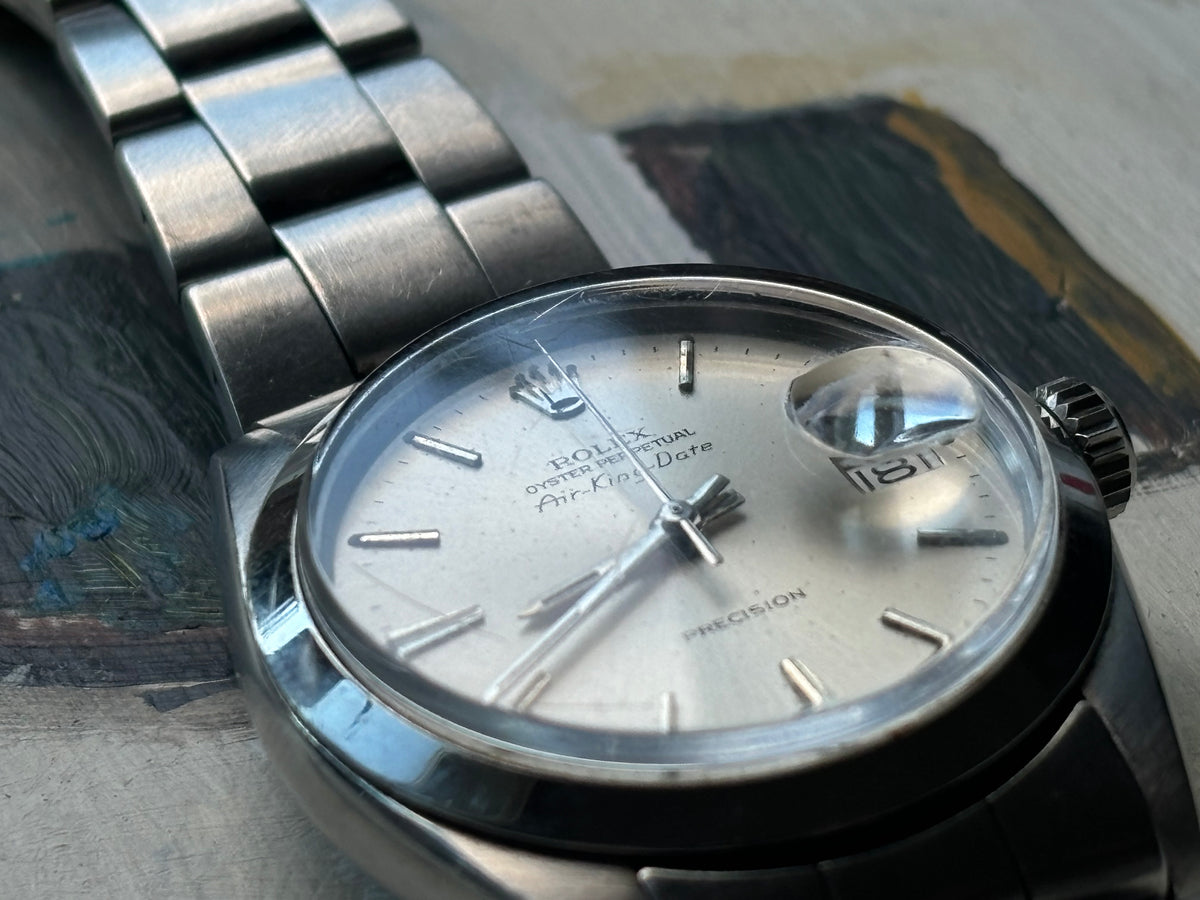 Studio close-up of Rolex Air-King-Date Precision ref. 5700 silver dial and polished stainless-steel case