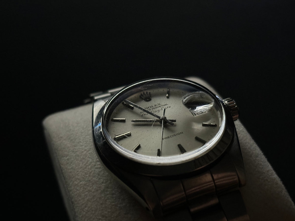 Low-angle studio photograph of vintage Rolex Air-King-Date Precision ref. 5700 with silver dial