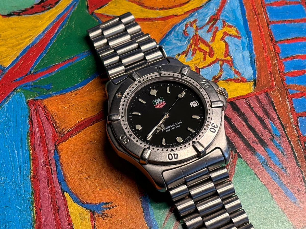 Flat-lay photograph of a vintage TAG Heuer Professional 200 Metres stainless-steel watch.