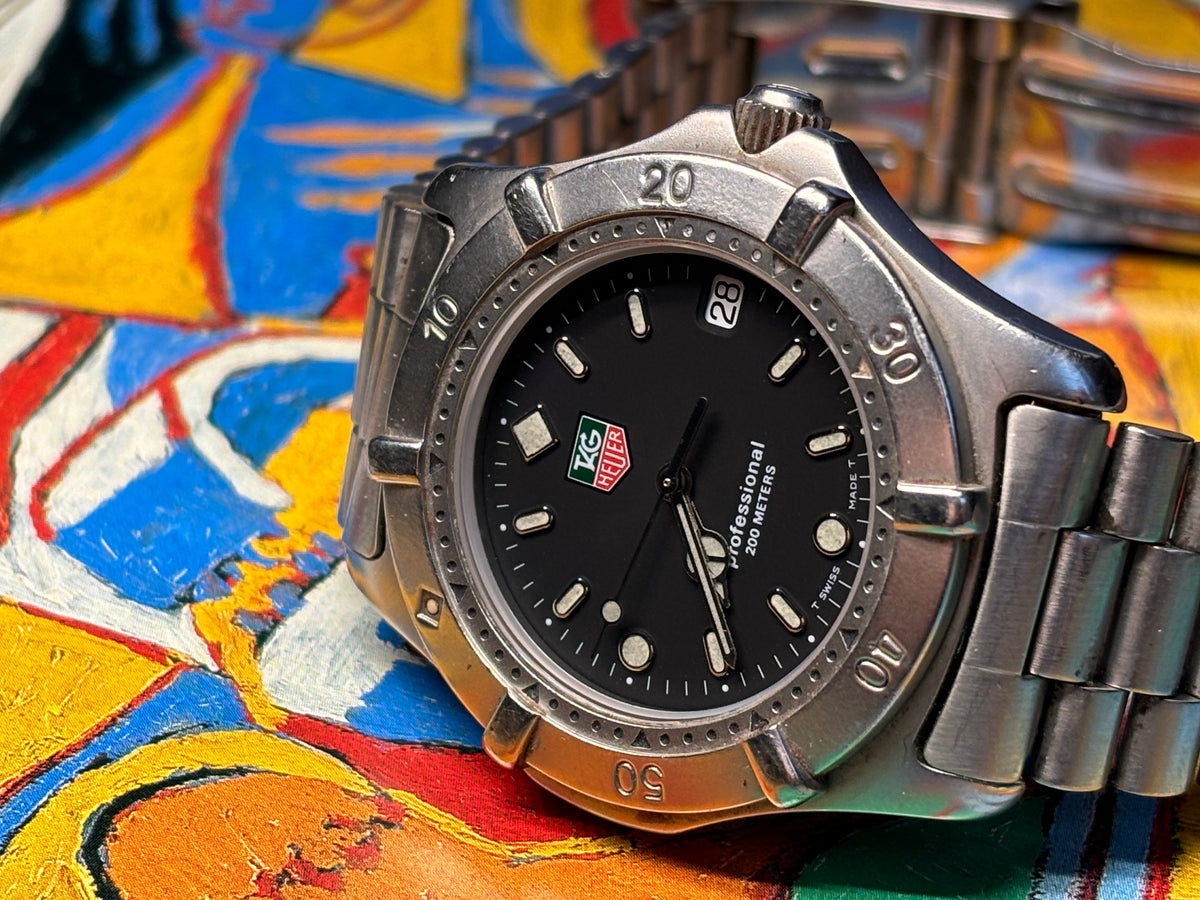 Three-quarter view of a vintage TAG Heuer Professional 200 Metres watch on its stainless-steel bracelet.
